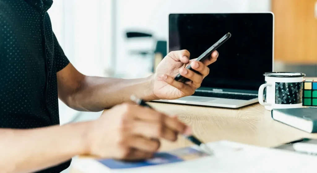 batch_man-at-desk-looking-at-his-mobile